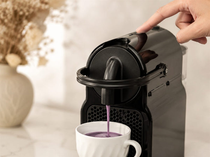 Extraction d'un café d'ube violet depuis une machine Nespresso Original, bouton espresso pressé