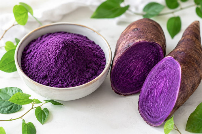 Bienfaits de l'ube : poudre violette, igname fraîche coupée et feuilles vertes