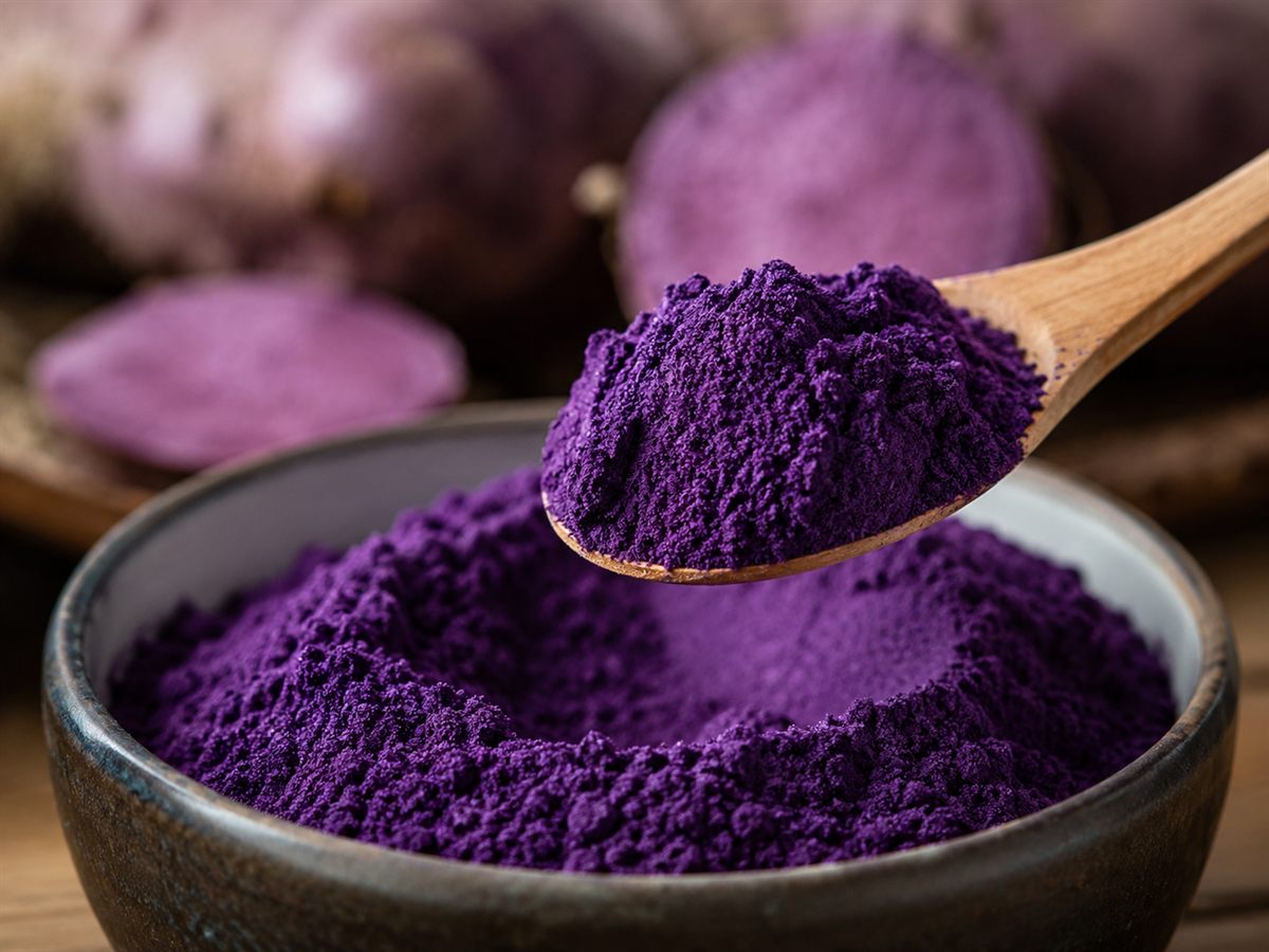 Poudre d'ube kinampay de qualité premium, violet profond, sur une cuillère en bois