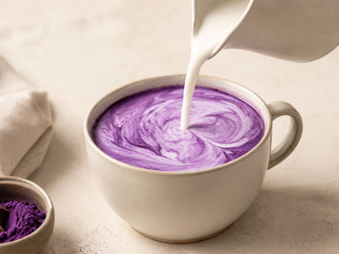Lait verse dans une tasse pour un latte violet a l ube