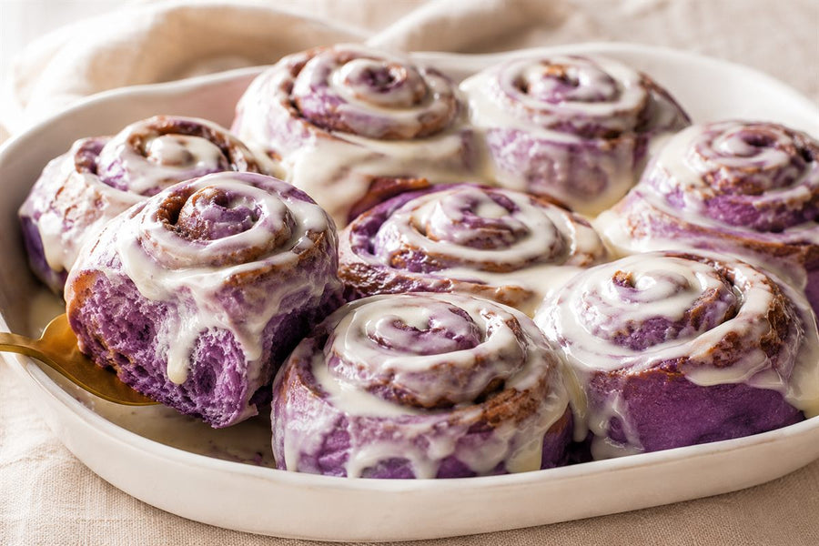 Cinnamon rolls à l'ube violets au glaçage blanc