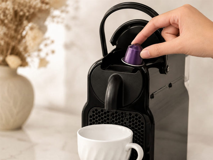 Insertion d'une capsule d'ube violette dans une machine Nespresso Original, levier levé