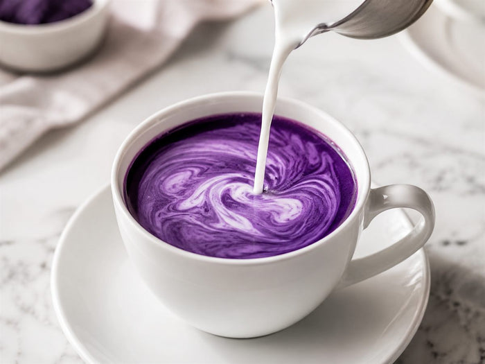 Ajout de lait dans un espresso d'ube pour préparer un ube latte violet