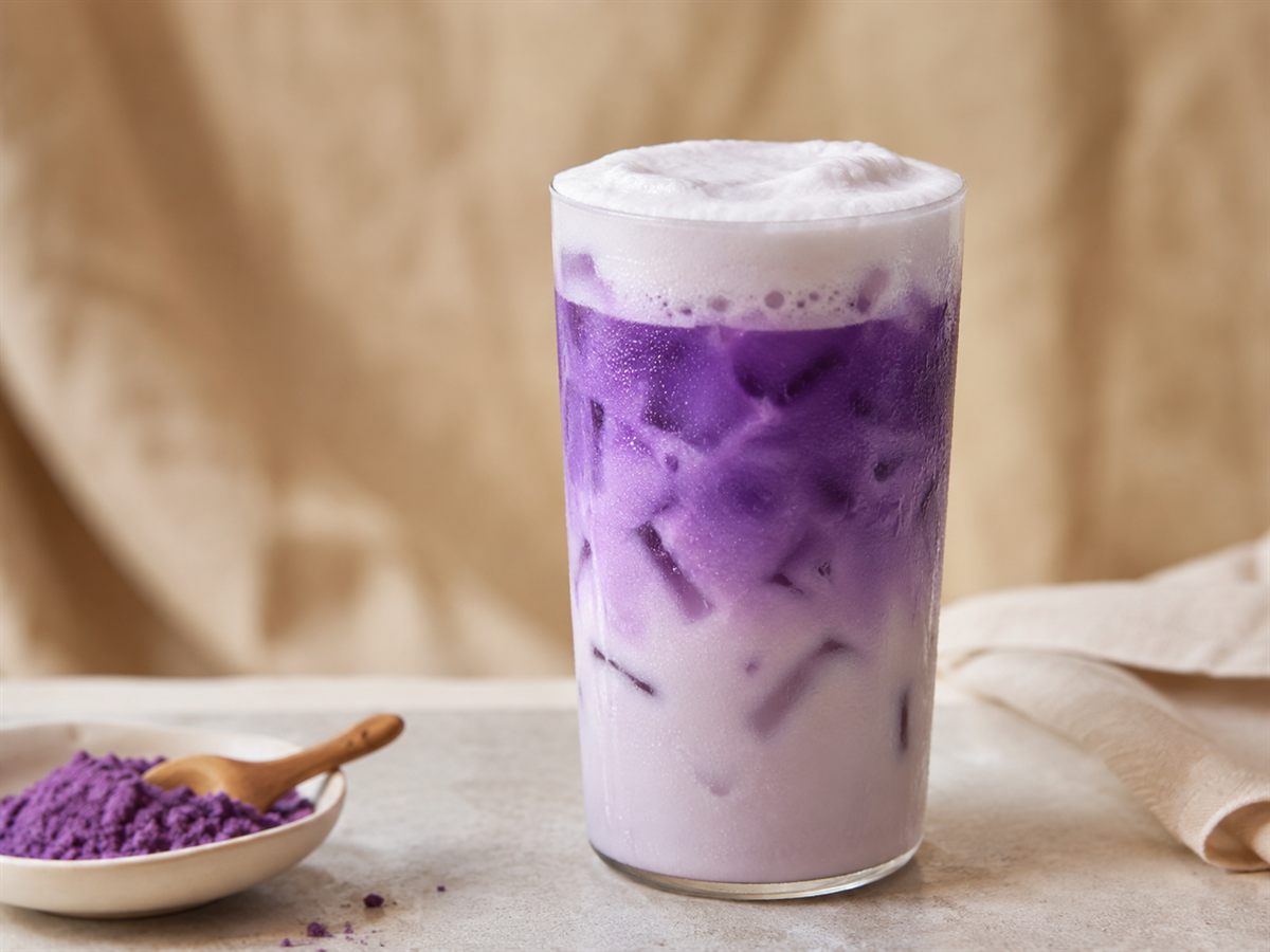 Ube latte glace violet vif sur glacons, mousse claire, poudre d'ube, fond lin