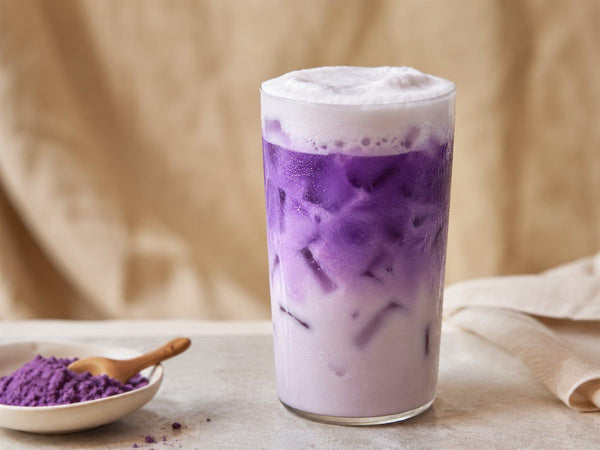 Ube latte glace violet vif sur glacons, mousse claire, poudre d'ube, fond lin