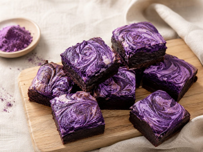 Brownies a l ube violets fondants et marbres, coupes en carres, fond lin beige