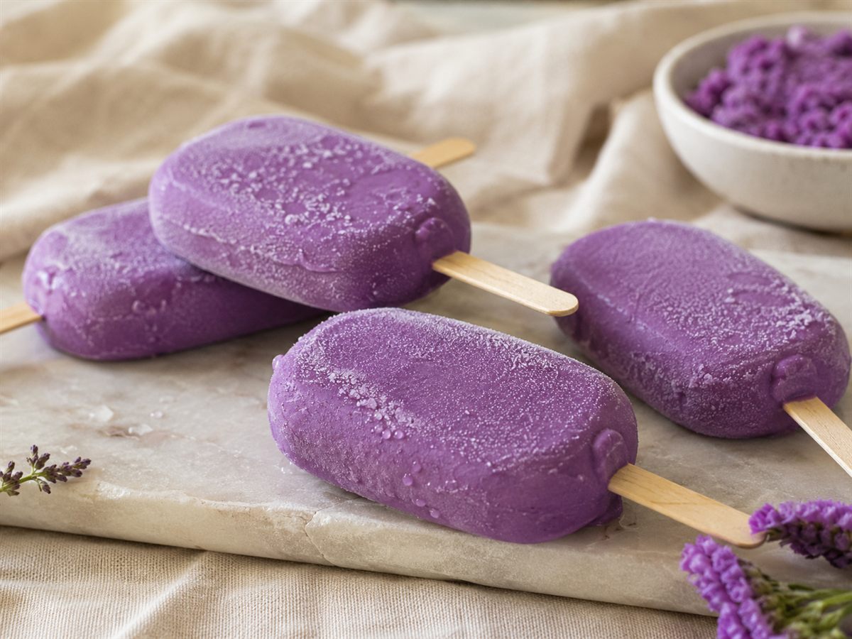 Esquimaux glaces a l'ube violets sur baton, givre, fond lin beige