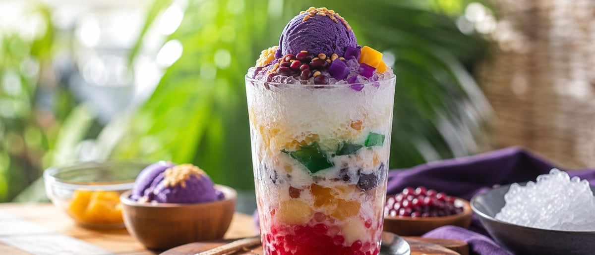 Grand verre de halo-halo avec glace à l'ube violet magenta, glace pilée et garnitures colorées