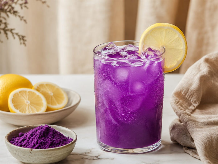 Limonade a l'ube violette glacee, glacons, rondelle de citron, fond lin beige