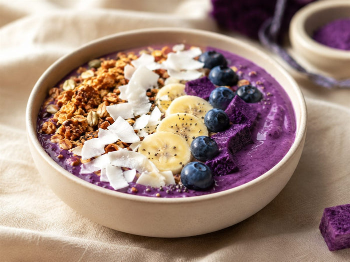 Purple dream bowl a l'ube violet gourmand, granola banane myrtilles coco, bol clair, fond lin