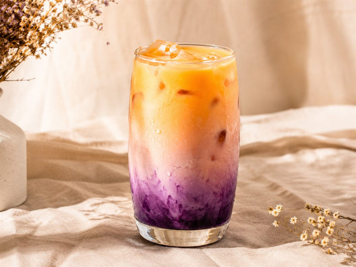 Ube purple sunrise latte degrade violet et orange, glacons, fond lin beige