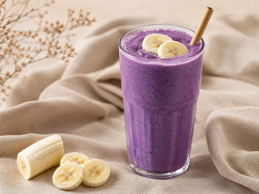 Smoothie a l'ube violet cremeux, rondelles de banane, paille, fond lin beige