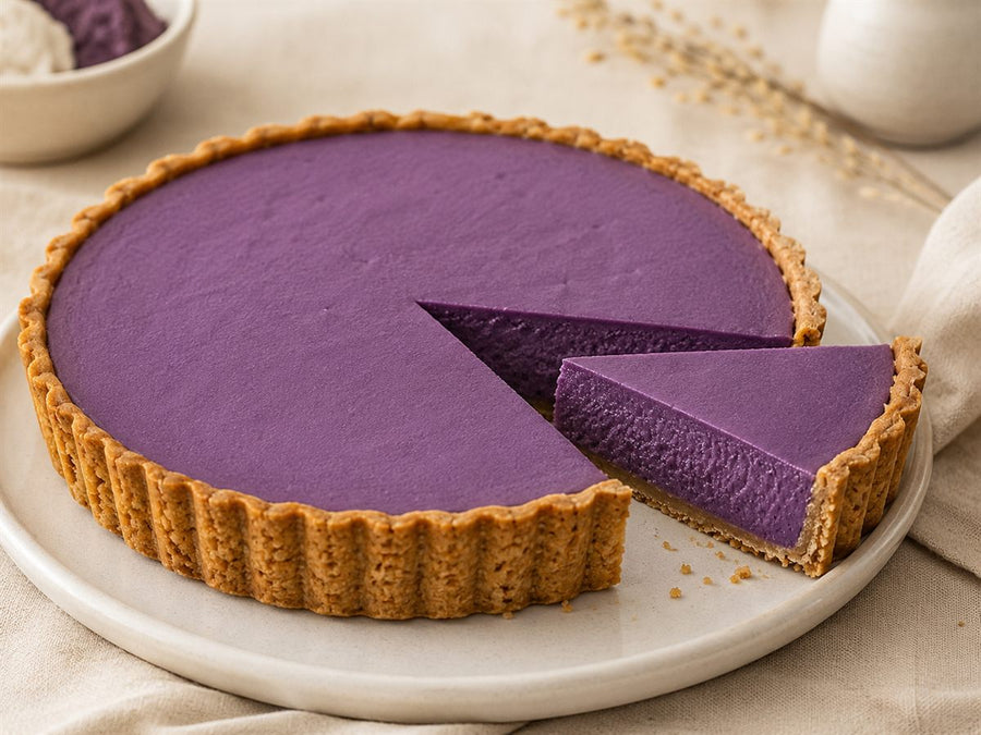 Tarte a l'ube, creme violette lisse, pate doree, part coupee, assiette claire, fond lin